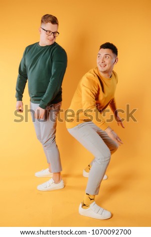 Two friends in casual colorful wear standing and laughing together. Best friends enjoying life. Two men having fun.joyful mans have nice time. Good relationship and friends concept