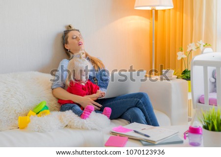 Exhausted mother fallen asleep in front of computer Royalty-Free Stock Photo #1070123936