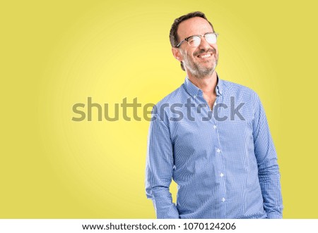 Handsome middle age man blinking eyes with happy gesture