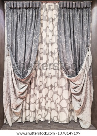 Interior decoration interior in brown tones. Straight double-sided curtains of dense fabric and tulle with abstract ornament. Royalty-Free Stock Photo #1070149199