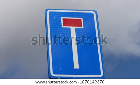 Close up sign dead end blue background against blue sky with white clouds, sign in the centre of the picture, Europe