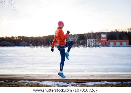 Potrtait of young athlete blonde at morning exercises in winter