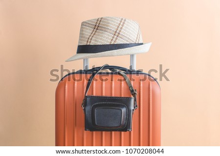 Suitcase with hat and retro camera. Travel equipment minimal creative concept.
