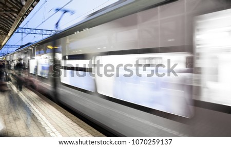 Motion blurred high speed moving passenger commuter railroad train at railway station or subway platform