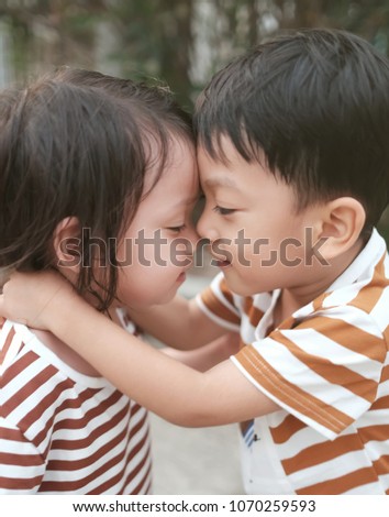 Soft focus on older brother try to kissing his sister. Closeup Asian kids show the Love. puppy love concept. concept of together, take care and expression of love . Composing picture with soft light. 