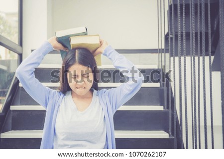 Beautiful of portrait asian young woman holding book, girl tired and bored reading book studying for exams, education and lifestyle concept.