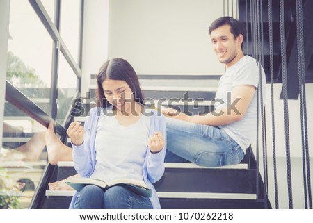 Couple asian handsome man and beautiful woman reading book and smile at home, boyfriend and girlfriend glad with activities together for leisure, education success concept.
