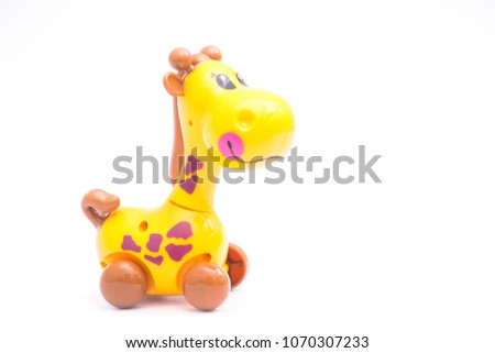 Mechanical giraffe toy. Clockwork plastic toy isolated on left hand with white background.