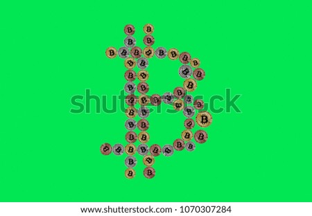 Bitcoin sign made of physical coins isolated on green background.