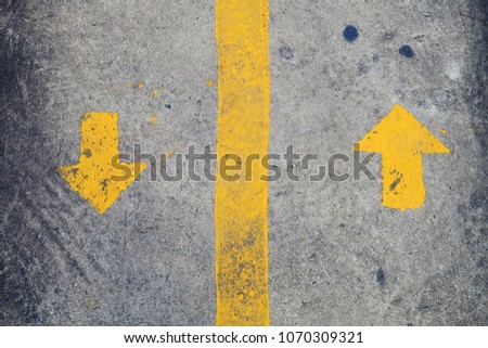ํYellow arrow symbol painted on pavement and road to clearly define lane path of  person or car 