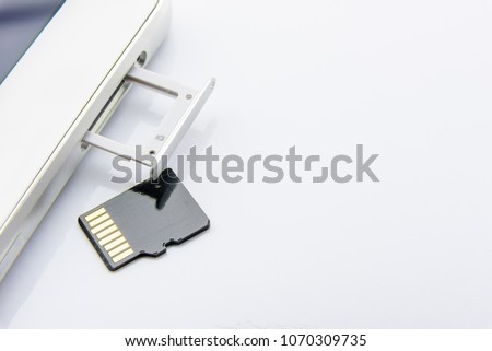 Flash memory data storage concept : A tray with a micro SD card on white background. A memory card is used for storing digital information in portable electronic devices e.g mobile phone, tablets, etc