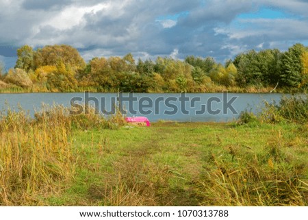 Autumn landscape. The shore of a small lake in sunny autumn day