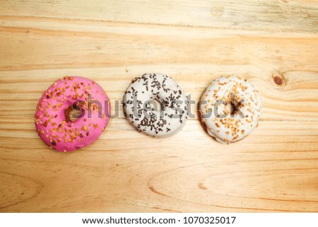 Colorful and tasty donuts on a wooden background
