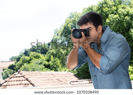 Tourist taking pictures with digital camera outdoors in summer