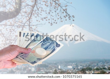 hand holding smart phone isolated on blurred Fuji mountain in Japan, travel insurance concept.