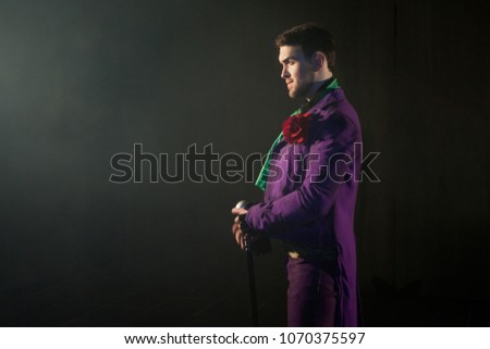 Showman. Young male entertainer, presenter or actor on stage. The guy in the purple camisole and the cylinder. Bright tailcoat, suit