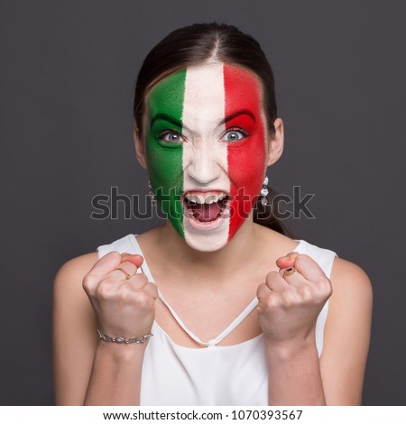 Portrait of happy woman with the flag of Italy painted on his face. Football or soccer team fan, sport event, faceart and patriotism concept. Studio shot at gray background, copy space