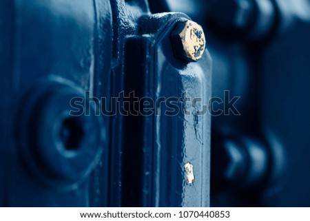 Blue metal rough surface of part with gold bolt. Blue painted of auto part. Automotive grunge background image.