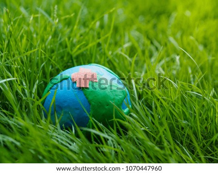 earth on the ground and green grass field background. environment save earth concept.