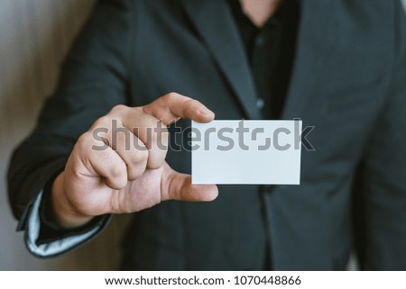 Business man holding white business card.
