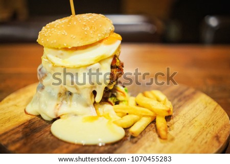 Abstract vintage picture style of big pile of hamburger with French fried in restaurant background, selected focus.