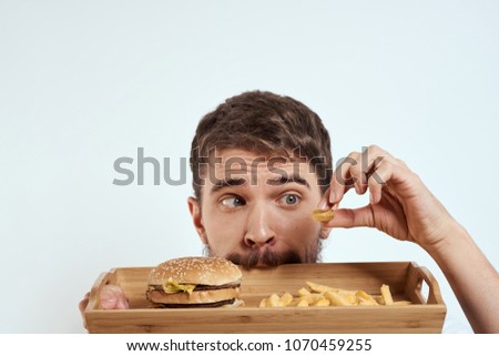  hungry man with a tray of fast food                              