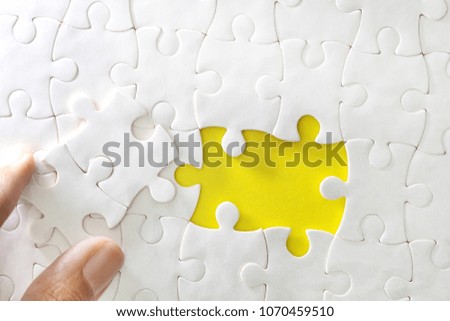 Close up piece of white jigsaw puzzle , concept of business challenge completion with teamwork