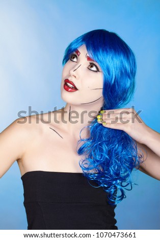 Portrait of young woman in comic  pop art make-up style.  Female in blue wig on blue background