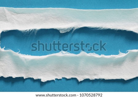pieces of torn paper texture on blue background, copy space