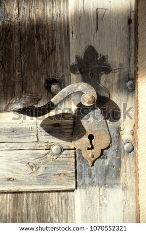 Europe Karnten Kirchbach 2003. Section of old wooden barn door with rusty handle and keyhole. Sun shadow on wood. Rustic.