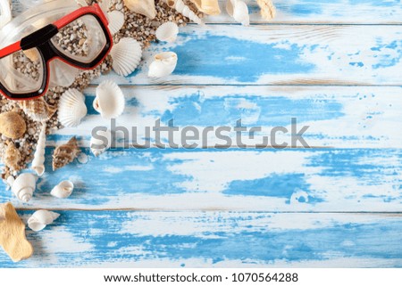 Beach accessories on vintage blue wooden board. Summer vacation concept.