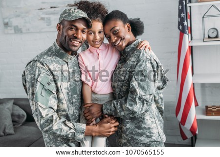 African american female and male soldiers embracing their daughter Royalty-Free Stock Photo #1070565155
