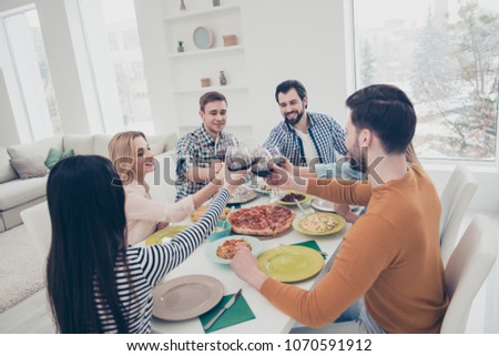 Six best, attractive, stylish, positive, friendly friends celebrating holiday indoor in house flat apartment clinking glasses with red wine sitting at table with homemade dishes enjoying holiday