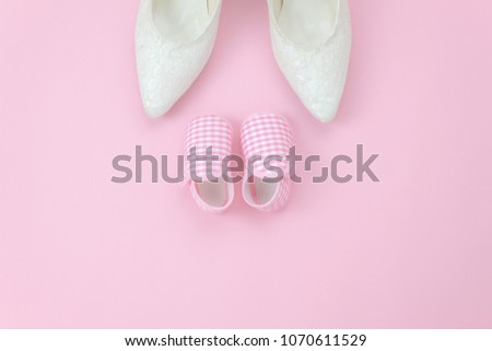 Top view aerial image of decorations Happy mothers day holiday background concept.Flat lay sign of season the pink rose with clothing woman & kid and child toys on pink paper at home office desk.