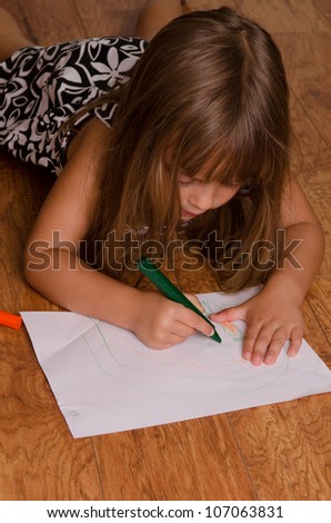 Girl coloring on the kitchen floor