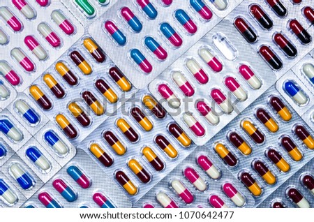 Full frame of colorful antimicrobial capsule pills. Quality control error in pharmaceutical manufacturing. Blister pack missing one capsule of antibiotic pill. Drug resistance. Defective concept. Royalty-Free Stock Photo #1070642477