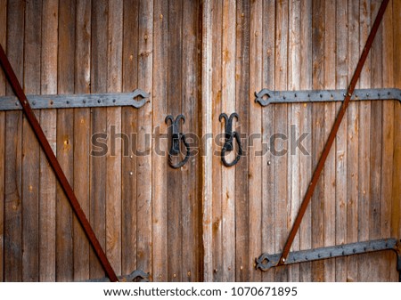 wooden gate with wrought iron elements close up.