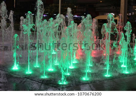 Green colorful fountain from water jets 
