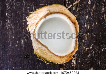 Picture of a cracked open coconut on a wooden table, Phi Phi Island, Thailand