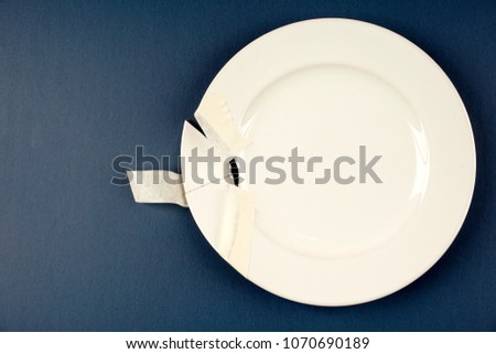 A broken plate fixed by using a sellotape over blue background