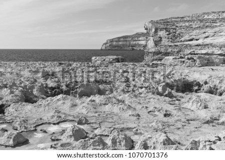 Gozo is a small island of the Maltese archipelago in the Mediterranean Sea.  Rugged coastline delineated by sheer limestone cliffs, and dotted with deep caves. Black and white picture