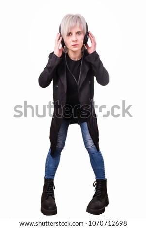 Young fashion stylish woman in big black boots with headphones. Isolated full body portrait on white background. Grunge style. Music lover concept