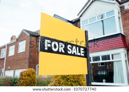 'For Sale' sign outside of a terraced house in the UK. 