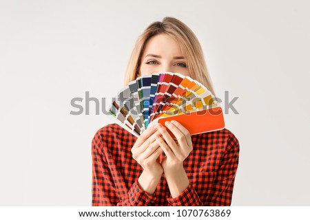 Young woman with color palette on white background Royalty-Free Stock Photo #1070763869