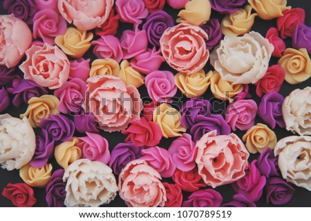 Mix of pink and Peach Fake Plastic Mini rosess Flowers Black Background copy space. Craft, Art, Hobby concept.
