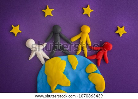 Group of people around the world. People and Earth with Stars are made out of play clay (plasticine). Close up.