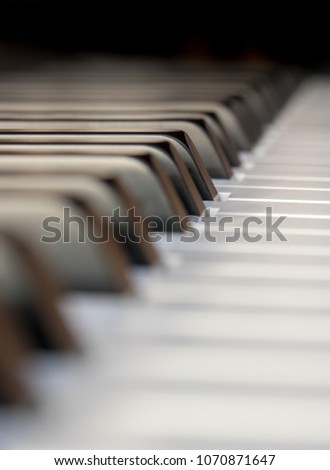 Side view of piano keyboard keys lost in the dark