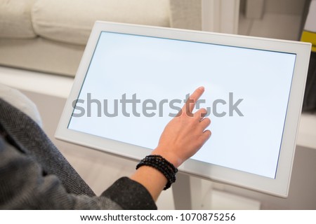 A woman touching the screen of self service device in the store. Royalty-Free Stock Photo #1070875256