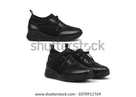Female black sneakers. Sport shoes isolated on white background. Fashionable footwear.