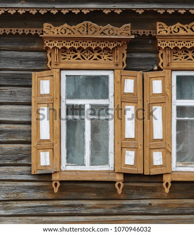 In the village house very beautiful windows with shutters and platbands in the Slavic style